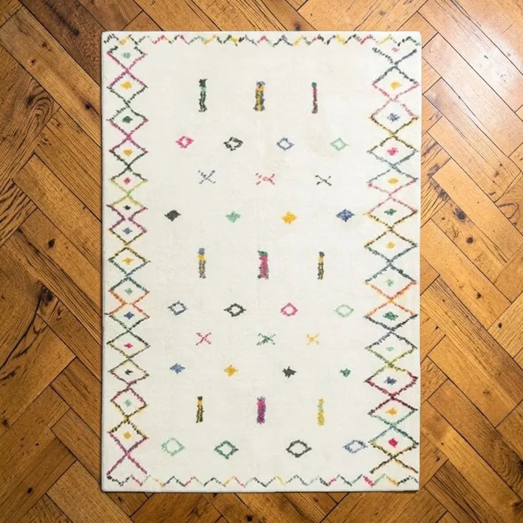 Tapis berbère SAHARA écru posé sur un parquet en bois.