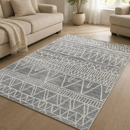 Tapis berbère TIFAWT gris et blanc aux motifs géométriques dans un salon lumineux.