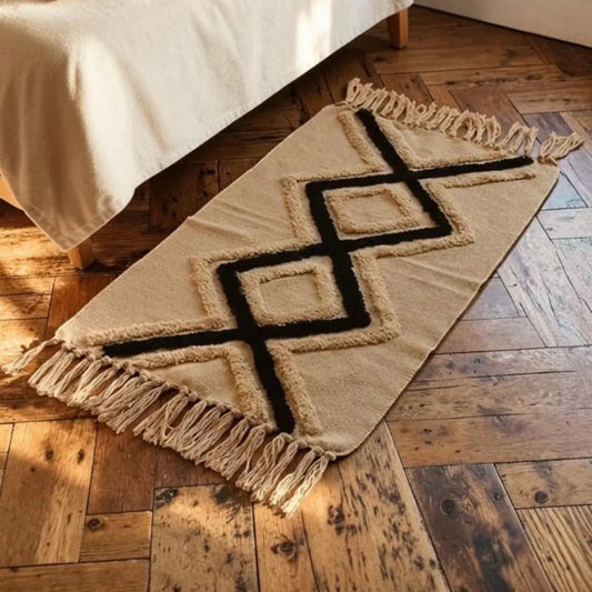 Tapis bohème ZAYMA placé au pied d’un lit sur un parquet ancien.