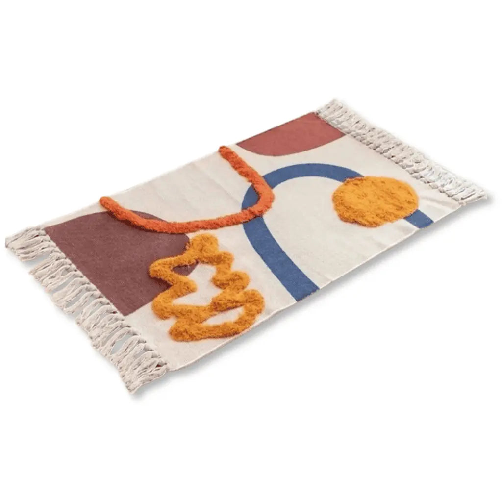 Tapis bohème écru aux formes abstraites en terracotta, bleu et ocre, avec franges.
