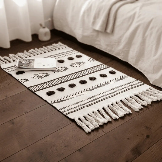 Tapis bohème NOMADE installé dans une chambre, au pied d’un lit.