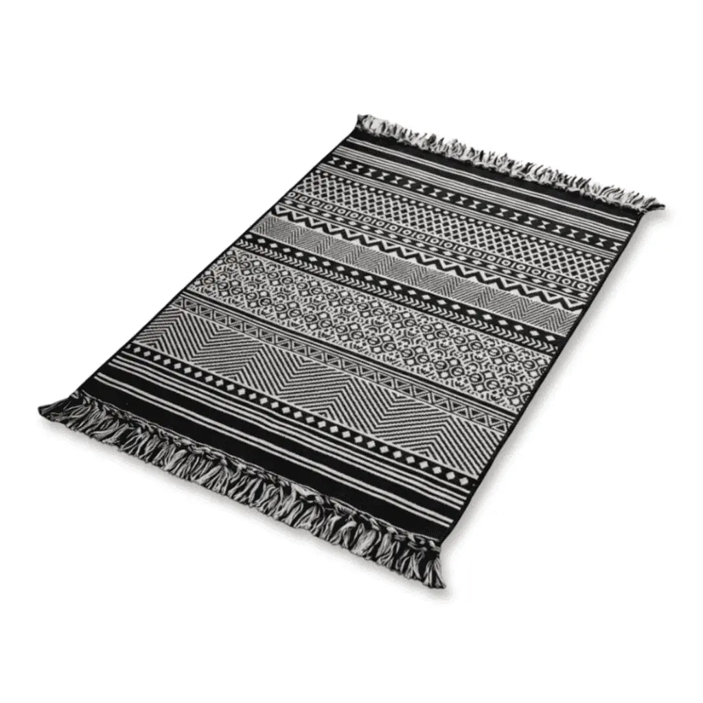 Tapis berbère noir et blanc à motifs ethniques géométriques et franges.