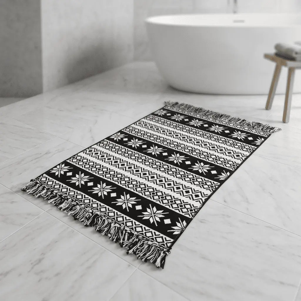 Tapis bohème noir et blanc orné de losanges, de chevrons et de motifs floraux stylisés.
