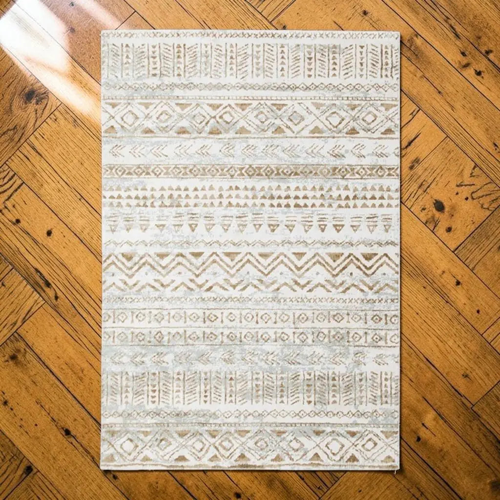 Tapis berbère beige et écru posé sur un parquet en bois.