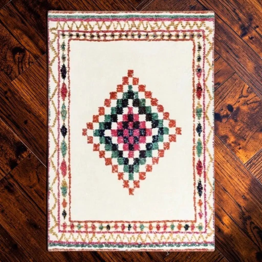 Tapis berbère écru avec bordure traditionnelle multicolore, posé sur un parquet en bois.
