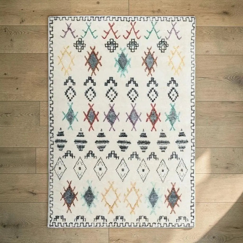 Tapis berbère écru et multicolore posé sur un parquet en bois clair.