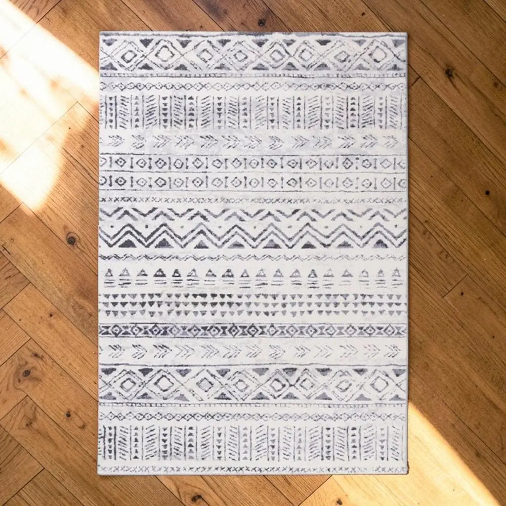 Tapis marocain bleu et blanc posé sur un parquet en bois.