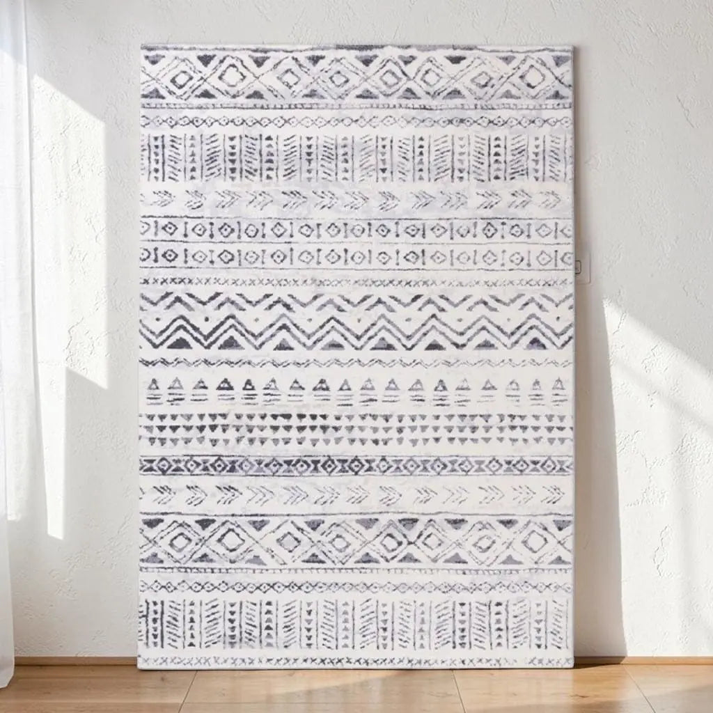 Tapis marocain à motifs géométriques bleus présenté contre un mur clair.