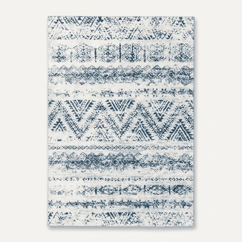 Tapis marocain écru décoré de motifs géométriques bleus, de losanges et de chevrons.