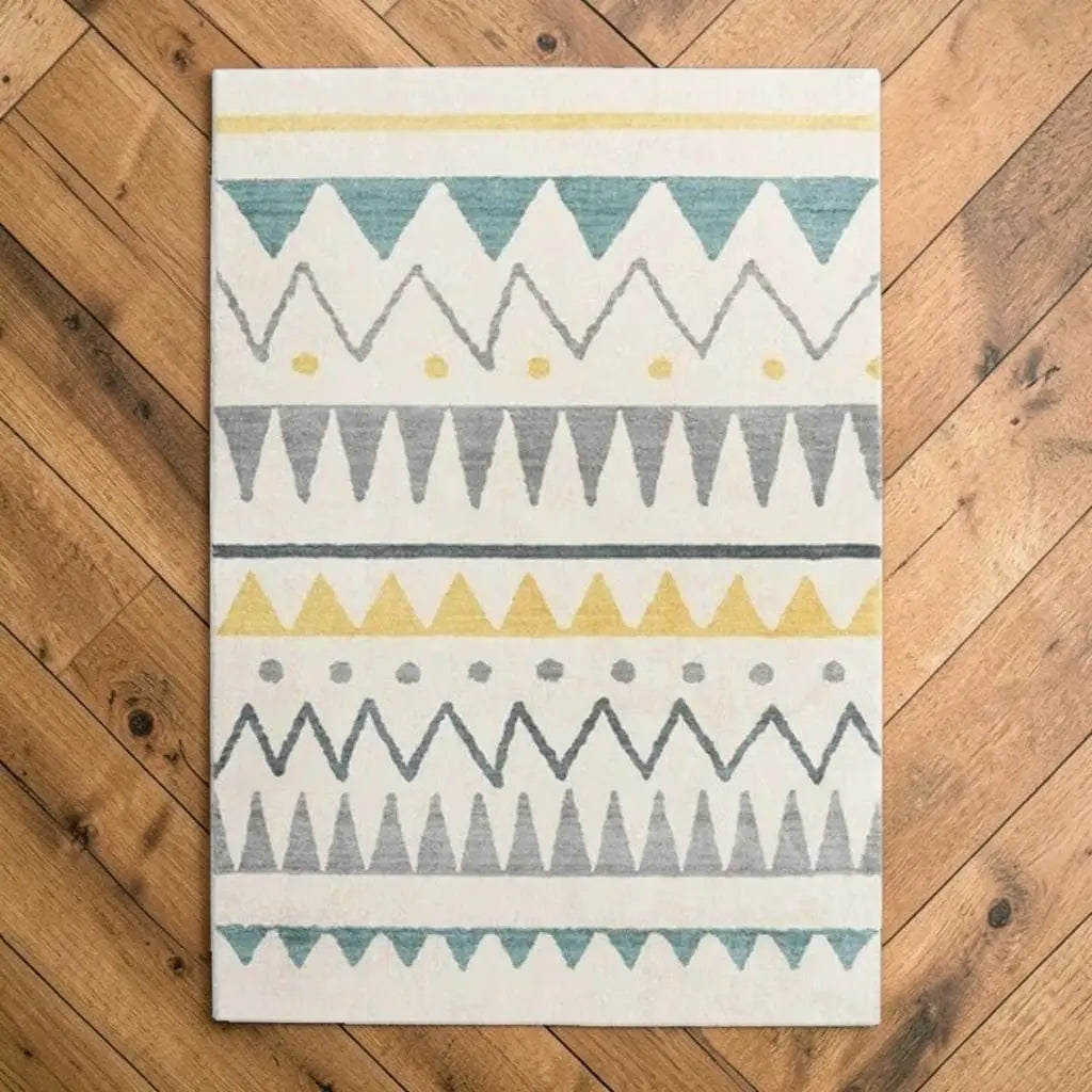 Tapis marocain aux motifs graphiques posé sur un parquet en bois.